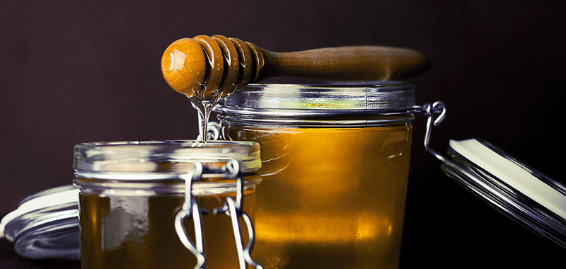 Honig im Glas mit Löffel